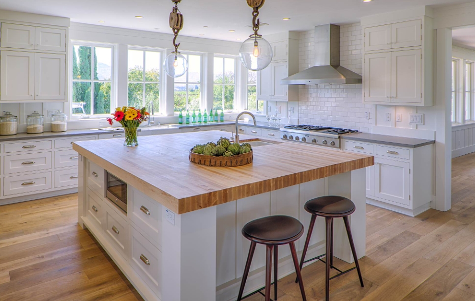 Farmhouse Kitchen with a Butcher Block Island and White Cabinets